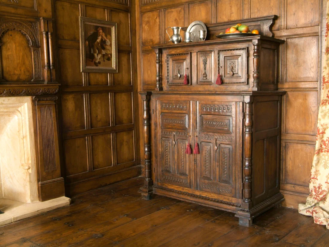 Carved oak court cupboard in a panelled room