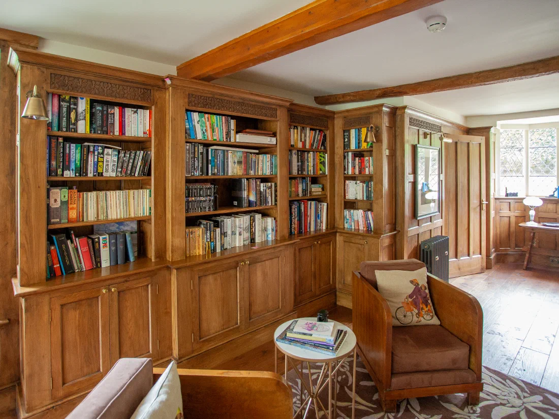 Arts & Crafts library with fitted oak bookcases and lower cupboards