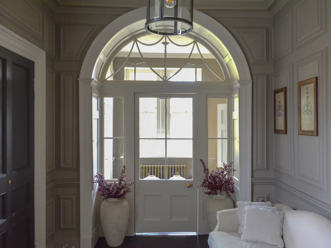 Arched glazed doorway set within painted Georgian panelling
